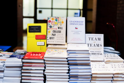 A stack of various business and leadership books displayed on a table.